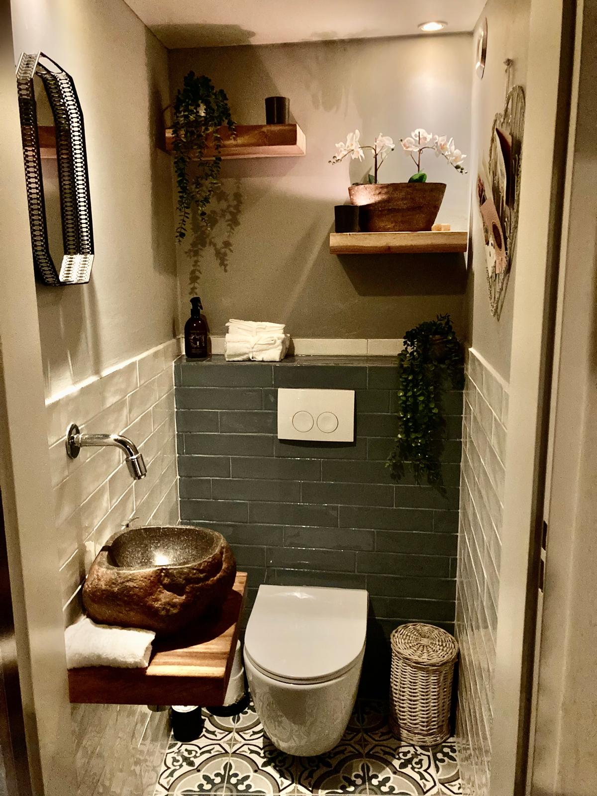 Toiletruimte met groene tegels en een vloer met patroon